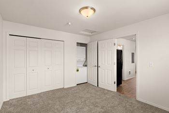 a bedroom with white closets and a door to the bathroom at Trillium Apartments, Springfield, 97477